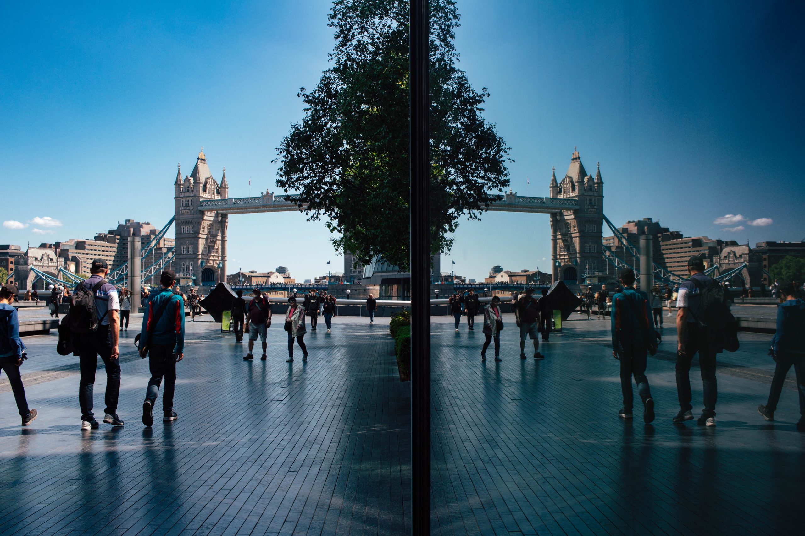 reflection of the tower bridge against a nearby building in London
